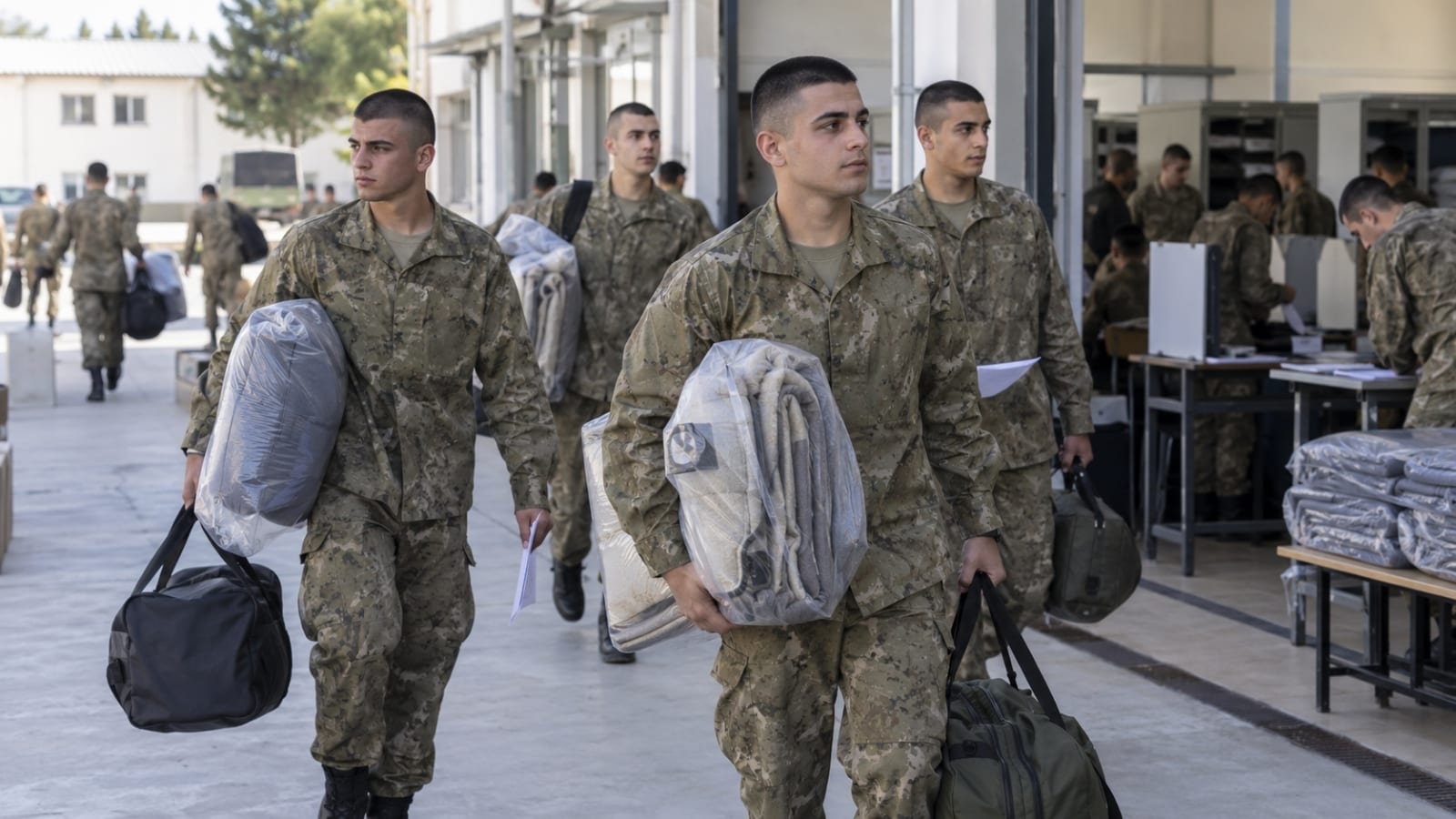 İlk gün işlemlerinin ardından askerî malzemelerini ve yatak takımlarını teslim alarak bölüğüne ilerleyen rütbesiz askerlik yükümlüleri